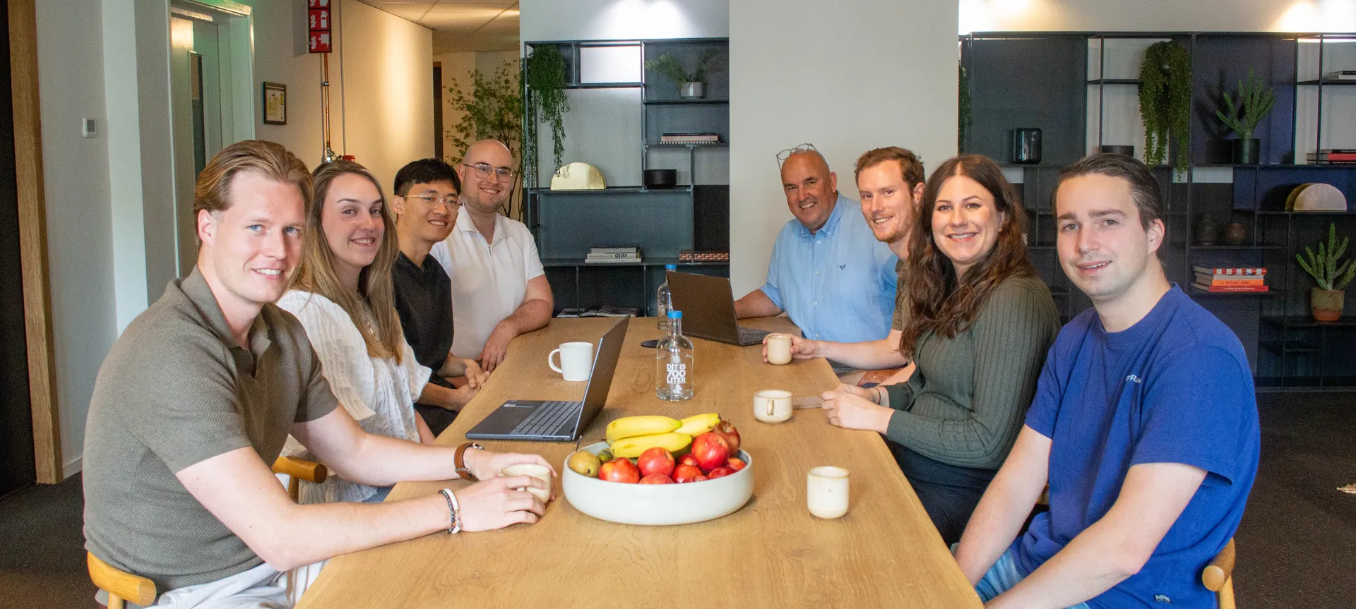 Het team aan tafel op kantoor